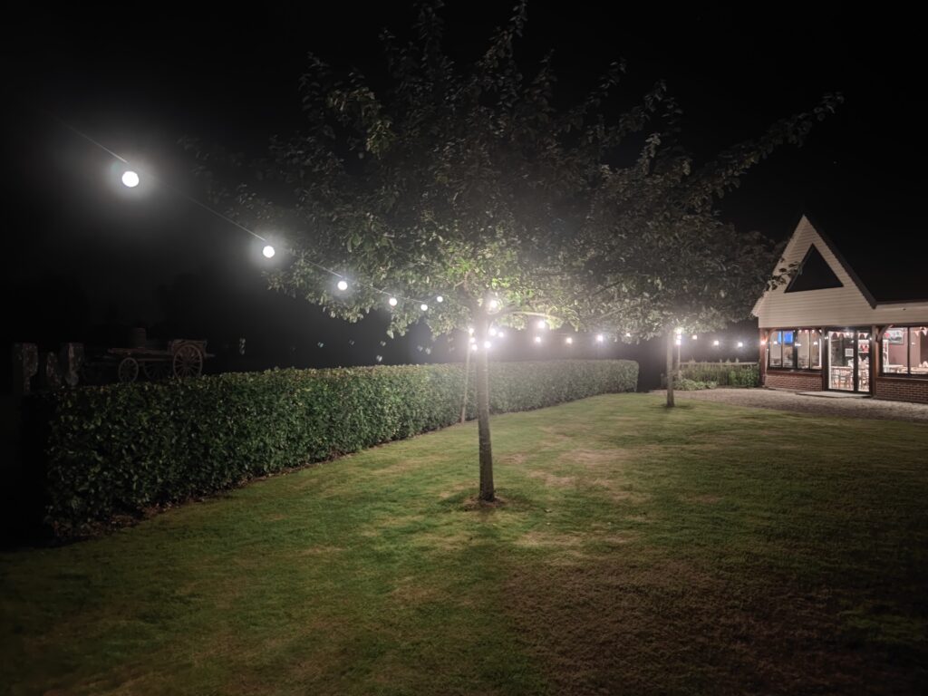 La cour illuminée de guirlandes à la nuit tombée