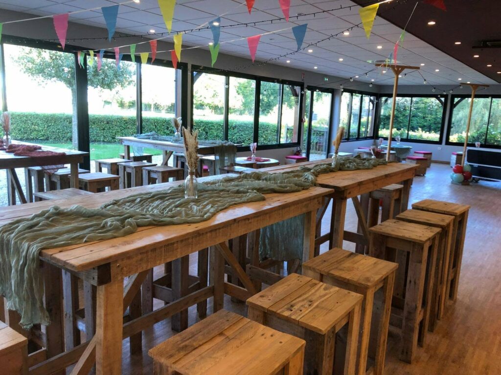 La salle aménagée en guinguette avec tables hautes et fanions