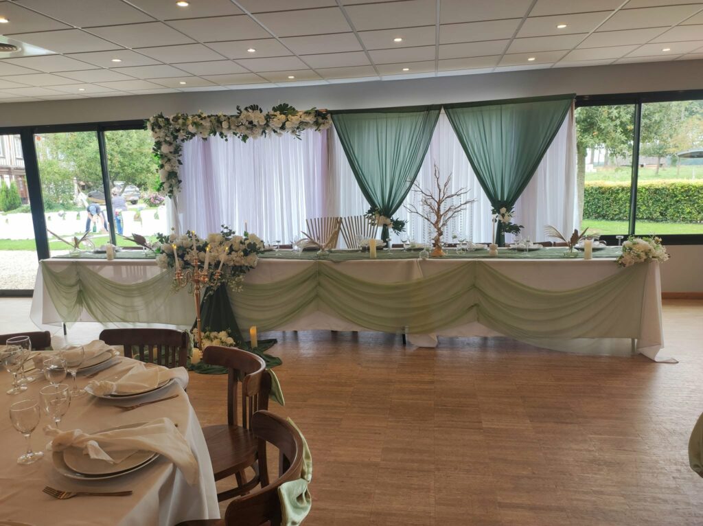 Table d'honneur décorée de voilages verts pour un mariage