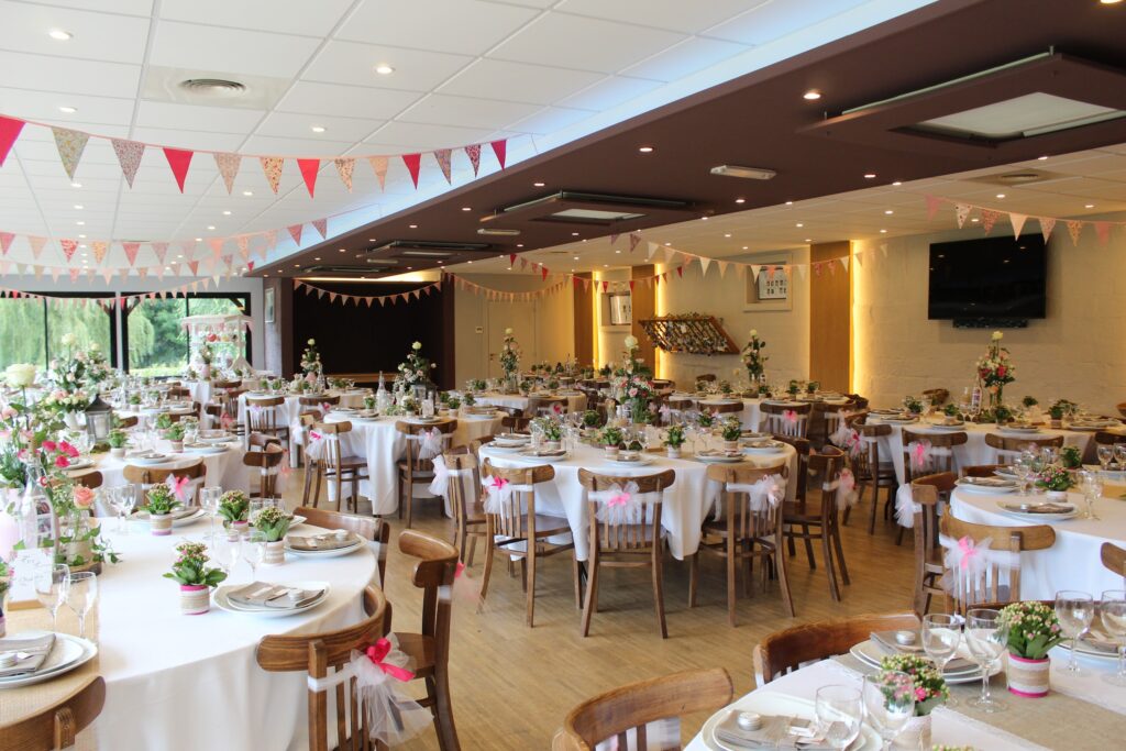 La salle dressée pour un mariage, fanions et tables rondes