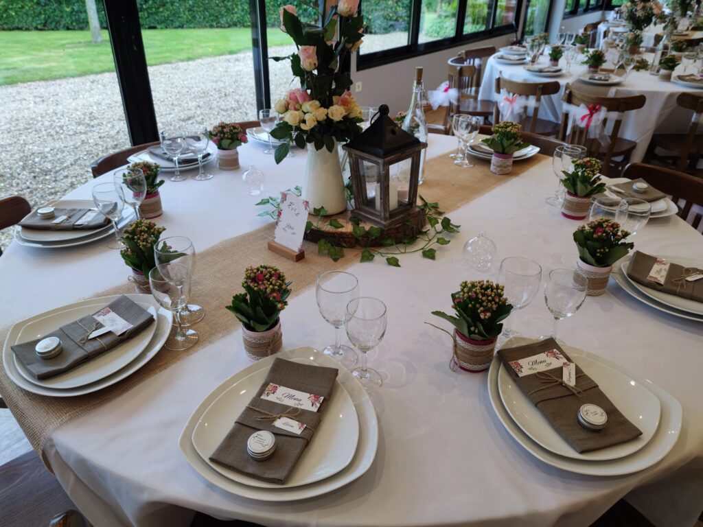 Table ronde dressée avec chemin de table en toile de jute et lanterne