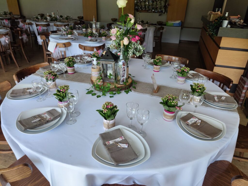 Table ronde dressée avec fleurs et serviettes en lin