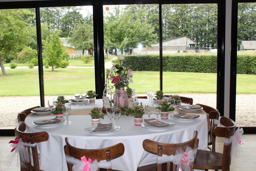 Table dressée devant les baies vitrées et le jardin